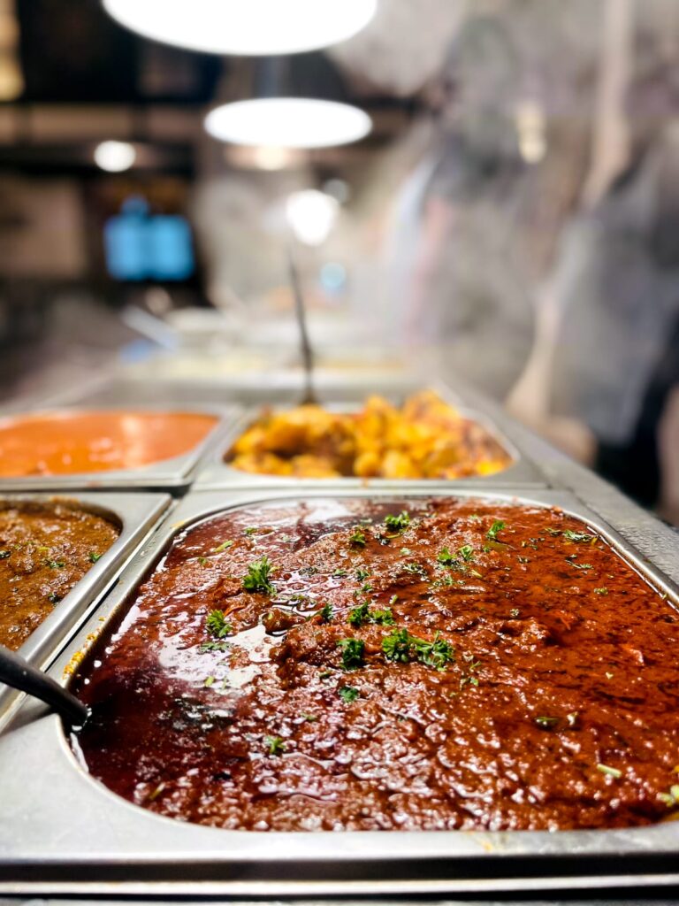 A selection of hot curries at the buffet counter